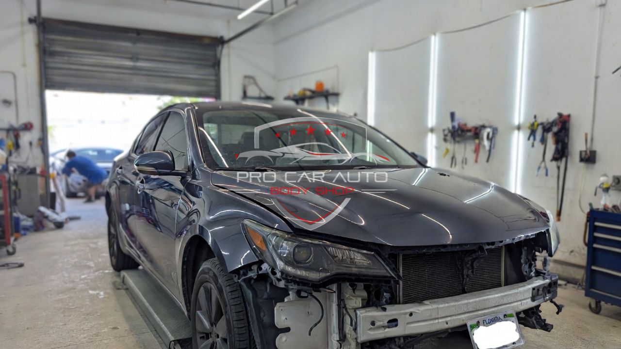 Front-end collision damage vehicle inside Florida auto body shop awaiting insurance claim repair under no-fault policy.